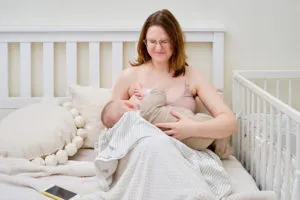 Madre lactante y bebé en la cama.